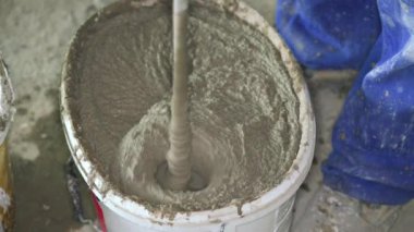 Havan topu çimento macunu, çoğunlukla kuru, ev inşaatında kovaya karıştırılmış, yukarıdan yakın çekim detayı.
