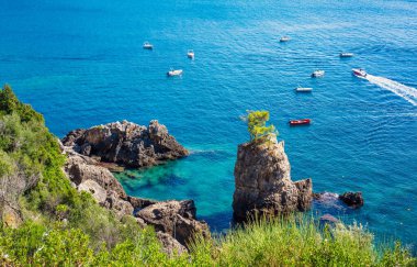 La Grotta Körfezi 'nde güzel bir deniz manzarası, Korfu, güneşli bir yaz günü - uzakta sakin denizde küçük tekneler.