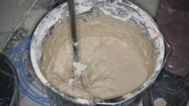 Islak harç macunu, ev inşaatında kovaya karıştırılmış, yukarıdan yakın plan detaylar.
