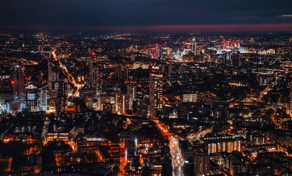 Aerial view of south west London, blue hour just after sunset, orange yellow street lights starting to glow