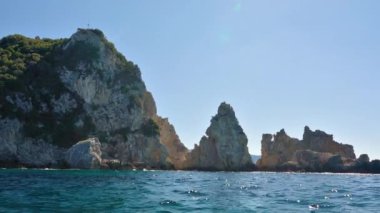 Suyun üzerinde görünen yüksek kayalık kayalıklar - Paleokastritsa yakınlarında tipik deniz manzarası, Korfu Yunanistan, bir tekneden manzara