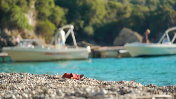 Chinelo Vermelho Sandália Sapatos Pequena Praia Seixos Mar Turquesa Calma — Vídeo de Stock