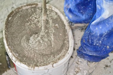 Havan topu çimento macunu, çoğunlukla kuru, ev inşaatında kovaya karıştırılmış, yukarıdan yakın çekim detayı.