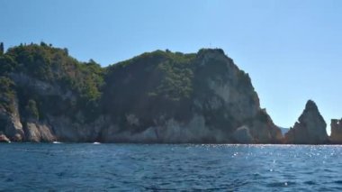 Suyun üzerinde görünen yüksek kayalık kayalıklar - Paleokastritsa yakınlarında tipik deniz manzarası, Korfu Yunanistan, bir tekneden manzara