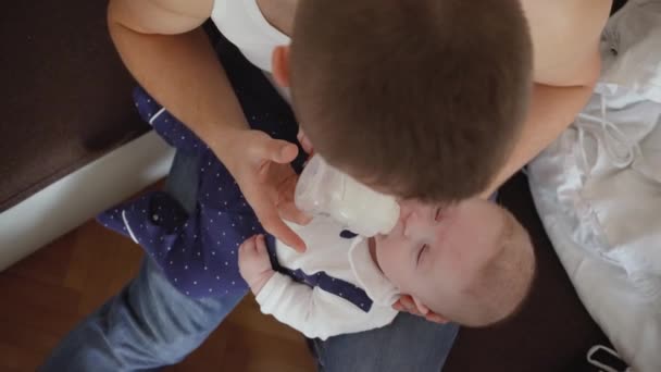 Młody Człowiek Karmiąc Mleko Jego Syn Chłopiec Butelki Widok Formularz — Wideo stockowe