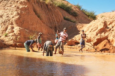 Ilakaka, Madagaskar - 30 Nisan 2019: Güneşli bir günde yüzey gölü madeninde safiri kazan bir grup meçhul Malagasy 'li adam.