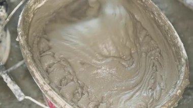 Islak harç macunu, ev inşaatında kovaya karıştırılmış, yukarıdan yakın plan detaylar.