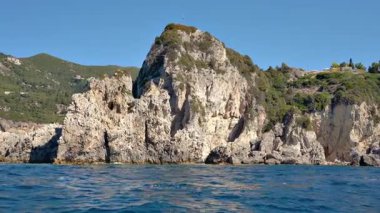 Suyun üzerinde görünen yüksek kayalık kayalıklar - Paleokastritsa yakınlarında tipik deniz manzarası, Korfu Yunanistan, bir tekneden manzara