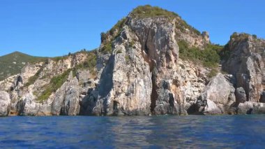 Suyun üzerinde görünen yüksek kayalık kayalıklar - Paleokastritsa yakınlarında tipik deniz manzarası, Korfu Yunanistan, bir tekneden manzara