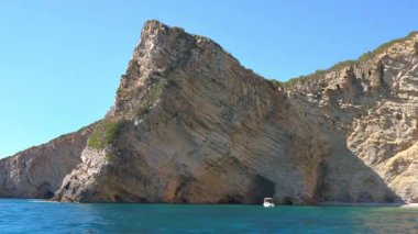 Yunanistan 'ın Liapades kentindeki Chomi veya Paradise plaj körfezi yakınlarındaki uçurumlarda görülen kaya jeoloji katmanları ön plandaki yeşil denizi sakinleştiriyor. Bir tekneden görüntü