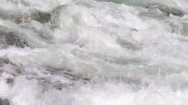 Sun shines on rapid river water, closeup abstract detail