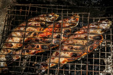 Piknikte ateşte ızgara balık, ızgarada ızgara yemek.