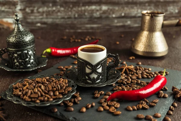 traditional turkish coffee in vintage cup, anise, roasted beans with hot spicy chili pepper on brown background 1