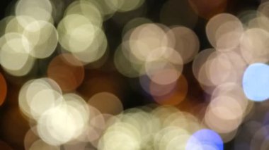 Çok renkli hareket eden Bokeh ışıkları kapanır. Mutlu Noel tatili dekorasyonu. Mutlu yıllar. Parıldayan Yumuşak-Odaklı Işıklar yanıp sönüyor. Odaklanma özellikleri. Lens Bokeh. İşaret fişeği. Karanlık Arkaplan. Kapat