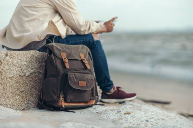 Turistler çantalarını yere bırakır ve eğlence, restoran ya da otel bulmak için haritalarını tutarlar. Sırt çantası ve seyahat kavramı.