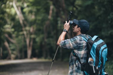 Yürüyüşçüler hayvanları görmek için dürbün kullanır ve ormanda yürürken sırt çantalı manzarayı görürler. yürüyüş ve macera konsepti.