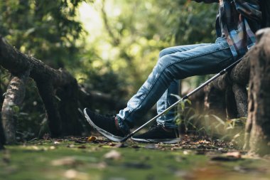 Ormandaki eski çitlerin üzerinde sırt çantalı bir yürüyüşçü dinlenirken. yürüyüş ve macera konsepti.