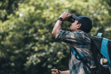 Yürüyüşçüler hayvanları görmek için dürbün kullanır ve ormanda sırt çantalı manzarayı görürler. yürüyüş ve macera konsepti.