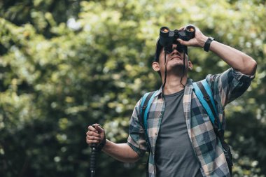 Yürüyüşçüler hayvanları görmek için dürbün kullanır ve ormanda sırt çantalı manzarayı görürler. yürüyüş ve macera konsepti.