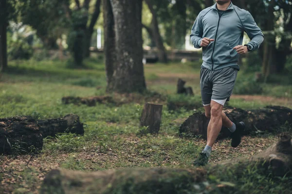 Ormanı yöneten sağlıklı yaşam tarzı genç bir fitness adamı. Açık hava sporu, sağlıklı yaşam tarzı konsepti.