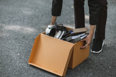 Şirketten kovulan ya da istifa eden işadamı, sokakta yeni bir iş arayan kutular taşıyor. İşsiz, işe alımlı, iş bırakma konsepti