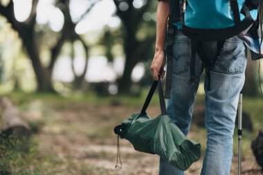 Yürüyüşçüler sırt çantalı yürüyüş direğini kullanır ve ormanda yürürken çadır çantasını tutarlar. yürüyüş ve macera konsepti.