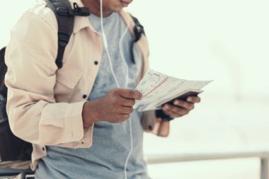 Turistler eğlence, restoran ya da otel bulmak için haritalar tutuyorlar. Sırt çantası ve seyahat kavramı.