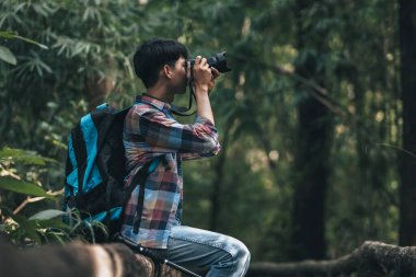 Sırt çantalı yürüyüşçüler ormanda kamera görüntüsü kullanır. yürüyüş ve macera konsepti.