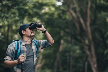 Yürüyüşçüler hayvanları görmek için dürbün kullanır ve ormanda sırt çantalı manzarayı görürler. yürüyüş ve macera konsepti.