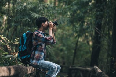 Sırt çantalı yürüyüşçüler ormanda kamera görüntüsü kullanır. yürüyüş ve macera konsepti.