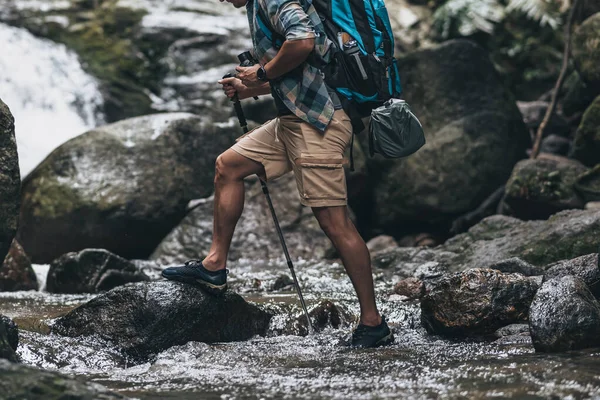 등산객들은 막대기를 사용하여 배낭을 바위와 물속을걸어 다닙니다 모험의 — 스톡 사진