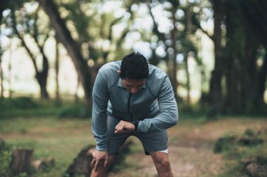Spor adamı antrenman sırasında ve parkta koşarken Akıllı Sahil Güvenlik 'e bakıyor. Açık hava sporu, sağlıklı yaşam tarzı konsepti.