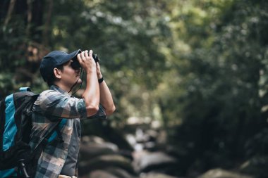 Sırt çantalı yürüyüşçüler ormanda çekim yaparken kamera kullanırlar. yürüyüş ve macera konsepti.