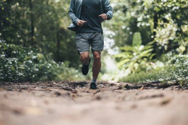 Ormanı yöneten sağlıklı yaşam tarzı genç bir fitness adamı. Açık hava sporu, sağlıklı yaşam tarzı konsepti.