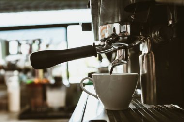 Kahve tezgahında espresso makinesi taze demlenmiş kahve ikram ediyor. Kahve makinesi konsepti.