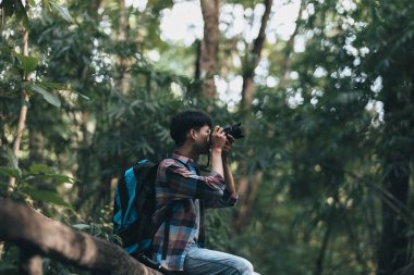 Sırt çantalı yürüyüşçüler ormanda kamera görüntüsü kullanır. yürüyüş ve macera konsepti.