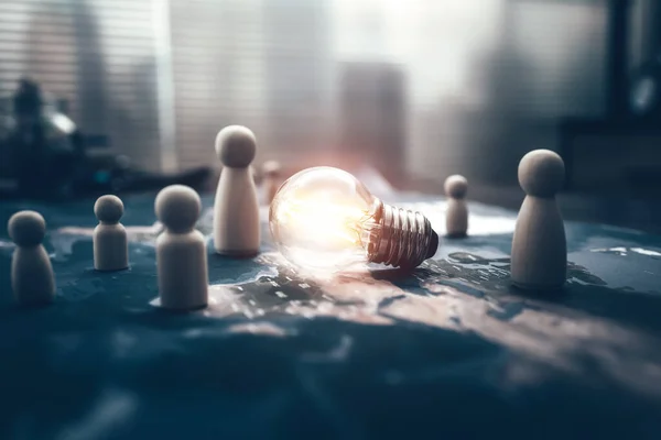 The wooden doll represents the employee of the company and light bulb on world map  represents networking, connection.  Idea, Corporation, Enterprise concept.