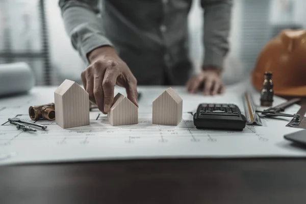 stock image house model and wood doll repersent family on blueprint. Architect and engineer concept.