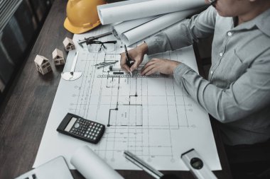 Mimar mühendis, plan üzerinde çalışan kalem ve mini T-slide tasarımı kullanır. Ev planlama ve inşaat konsepti.