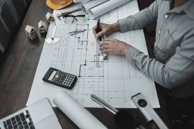 Mimar mühendis, plan üzerinde çalışan kalem ve mini T-slide tasarımı kullanır. Ev planlama ve inşaat konsepti.