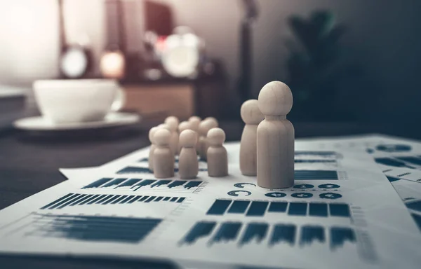 The wooden doll represents the employee of the company line up on business graph in workplace and them represents new employee, search job or job career.  Corporation, Enterprise concept.