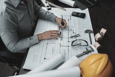 Mimar mühendis, plan üzerinde çalışan kalem ve mini T-slide tasarımı kullanır. Ev planlama ve inşaat konsepti.