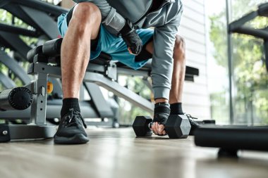 Spor salonunda halterle pazı egzersizi yapan bir adam. Fitness, egzersiz ve trans konsepti.