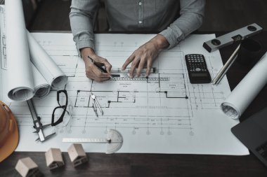 Mimar mühendis, plan üzerinde çalışan kalem ve mini T-slide tasarımı kullanır. Ev planlama ve inşaat konsepti.