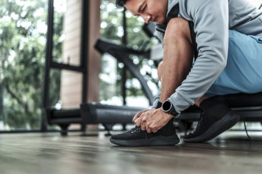 Spor salonunda bağcıklarını bağlayan adamın elleri. Fitness, egzersiz ve konseptte geçiş.