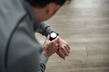 Spor salonunda antrenman yaparken Akıllı Sahil Güvenlik 'i kontrol eden bir adam. Fitness, egzersiz ve konseptte geçiş.