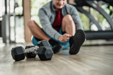 Spor salonunda bağcıklarını bağlayan adamın elleri. Fitness, egzersiz ve konseptte geçiş.