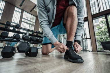 Spor salonunda bağcıklarını bağlayan adamın elleri. Fitness, egzersiz ve konseptte geçiş.