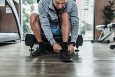 Spor salonunda bağcıklarını bağlayan adamın elleri. Fitness, egzersiz ve konseptte geçiş.