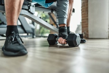 Spor salonunda halterle pazı egzersizi yapan bir adam. Fitness, egzersiz ve trans konsepti.